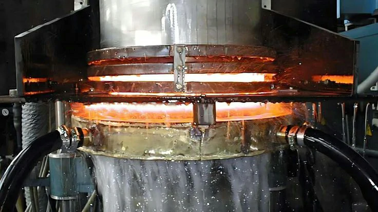 Industrial heat treatment process with glowing hot metal undergoing quenching for enhanced hardness and durability.