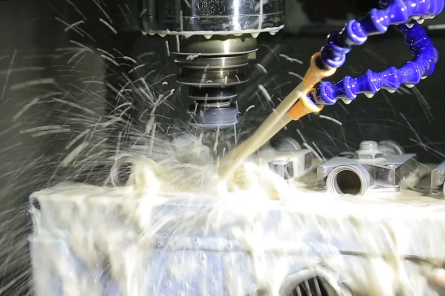 CNC milling machine spraying coolant on a metal part during cutting process