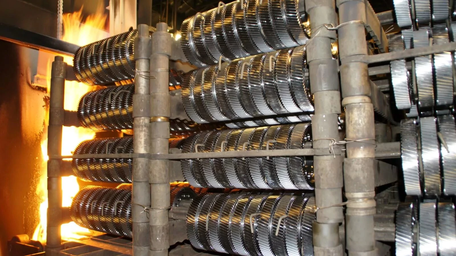 Pièces métalliques dans des supports soumises à un traitement thermique industriel dans un four afin d'améliorer leur résistance et leur durabilité.