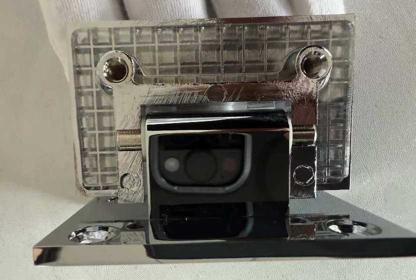 Close-up of grid-style brass hinge clamping surface designed to increase friction and prevent slipping on frameless glass doors.