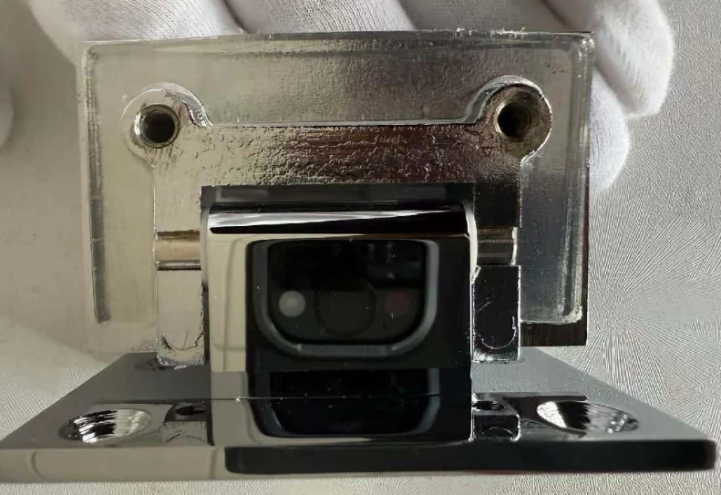 Detail view of a wall-to-glass shower hinge mechanism, showcasing the precision die-cast brass construction.