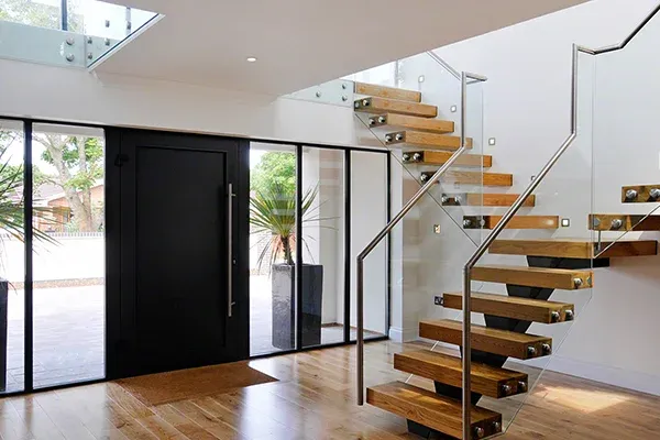 Escalier flottant moderne avec fixations d'écartement pour garde-corps en verre et acier inoxydable